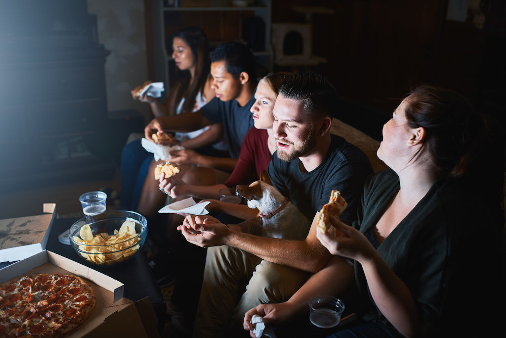 Group of friends watching TV in a dark room